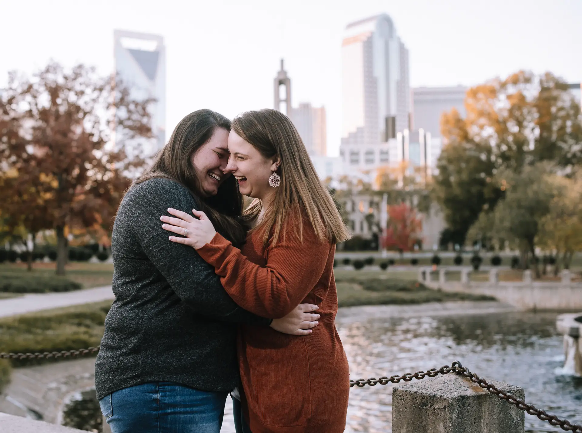 Playful and candid Charlotte engagement photo of couple laughing at Marshall Park.