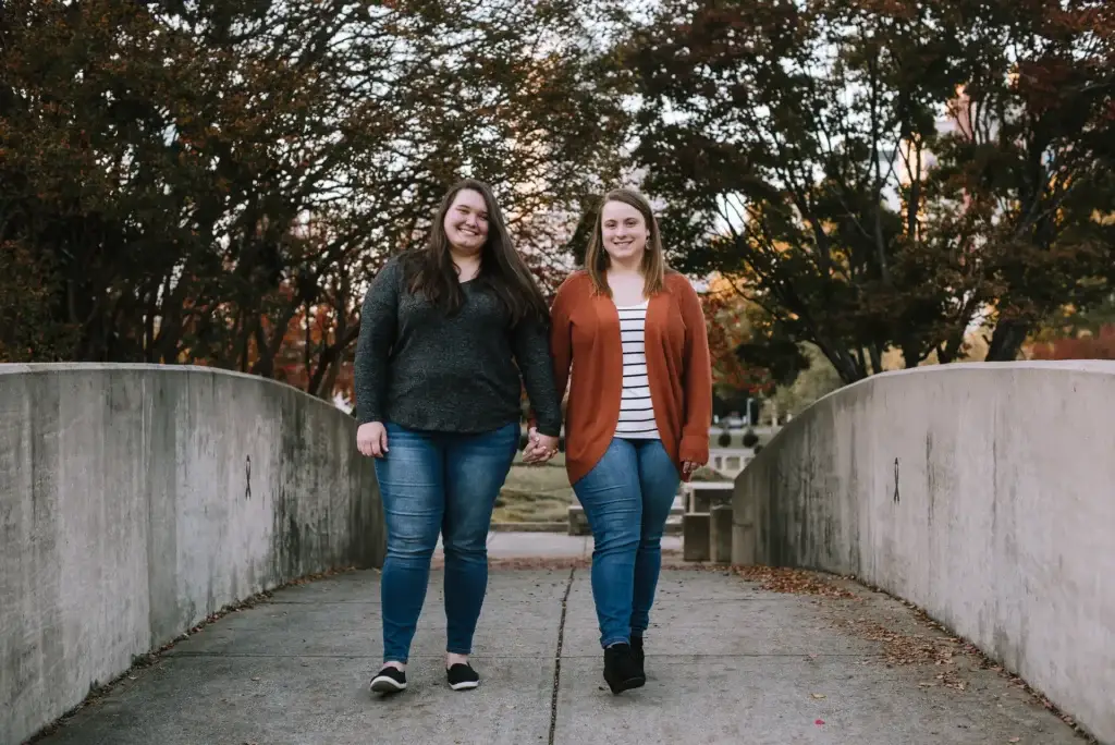 A beautiful couple walks on a bridge at Marshall Park in Charlotte, NC during their engagement photography session