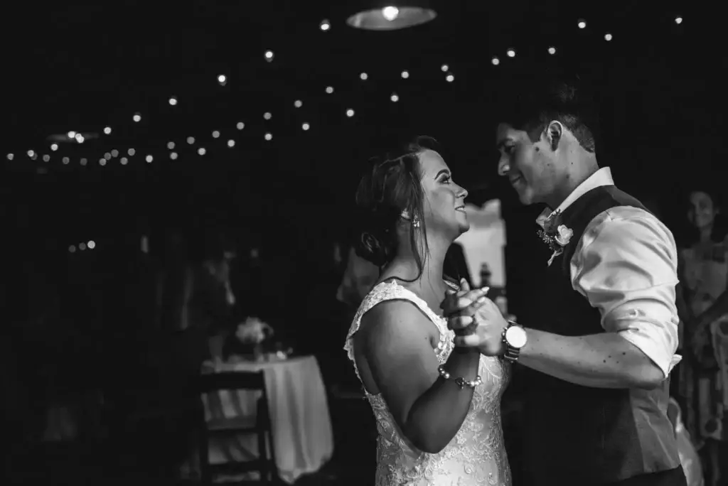 A couple gaze at each other while they dance at their wedding reception at the Field Trial Barn in the Anne Springs Close Greenway in Fort Mill, SC.